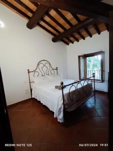 Un dormitorio con una cama blanca en una habitación. en La casa dei breton, en Magione