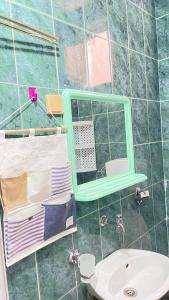 a bathroom with a green mirror and a sink at Hostel Flash in Ulcinj