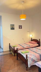 two twin beds in a bedroom with a light at Hostel Flash in Ulcinj