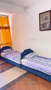 two twin beds in a room with a window at Hostel Flash in Ulcinj
