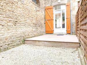 an entrance to a brick building with a wooden door at Studio coeur de ville paisible in Alençon