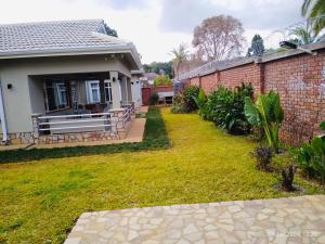 The Reserve Bed and Breakfast في هراري: منزل من الطوب مع مقعد في الفناء