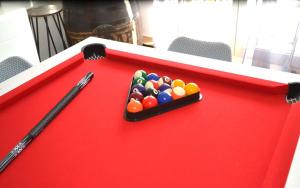 a red pool table with a cue and balls at Spassionnement pool in Jouy-le-Moutier +38 photos
