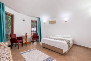 una camera da letto con un letto, un tavolo e delle sedie di Yörük Park Pansiyon a Kemer