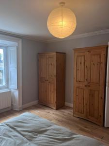 una camera con letto, armadi in legno e lampada di Spacious one bed apartment in the centre of Bray a Bray