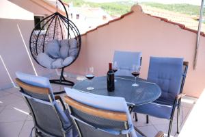 a table and chairs with wine glasses on a balcony at Apartments Maris in Vinišće