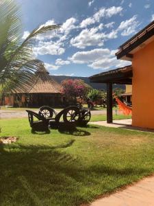 a group of benches in the grass next to a building at Pousada e restaurante Jardim do Cerrado MT in Nobres