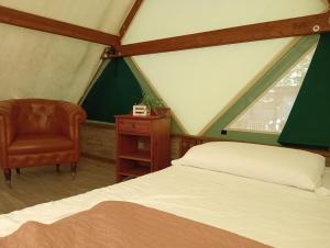 a bedroom with a bed and a chair in a tent at Parco Del Lago Glamping And Camping in Anguillara Sabazia