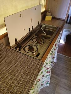 a stove top in a kitchen with a rug at Parco Del Lago Glamping And Camping in Anguillara Sabazia +83 photos