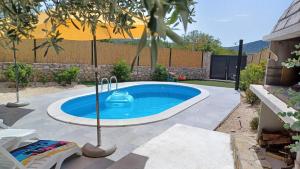 a small swimming pool in a backyard with an umbrella at M&S Paradise Bilice, Šibenik in Vrulje