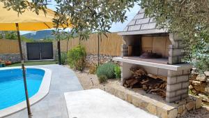 a outdoor fireplace next to a swimming pool at M&S Paradise Bilice, Šibenik in Vrulje