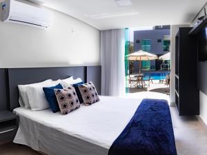 a bedroom with a large bed with blue and white pillows at Escarpas Eco Village in Capitólio +90 photos