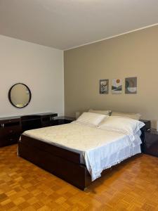 a bedroom with a bed and a mirror on the wall at La Casa dei Nonni in Alano di Piave