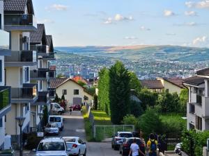 a street in a town with cars parked on a hill at Bună Ziua apartment Tonitza Nic. in Cluj-Napoca