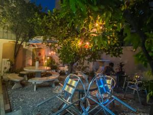a patio with chairs and a table and a tree at Green Garden Hostel in Bangkok