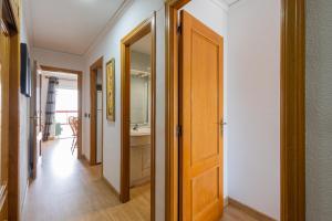 un couloir avec une porte menant à une salle de bains. dans l'établissement FABULOSO APARTAMENTO CON VISTAS AL MAR, à Playa de Gandia