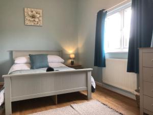 a bedroom with a bed with a cat sitting on it at Nightingale Lodge - Adults Only in Lackford +15 photos
