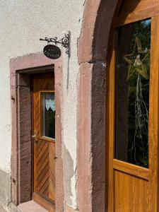 una puerta a un edificio con una señal encima en GÎTE EMERAUDE, en Plaine