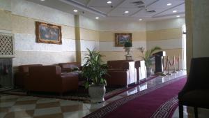 a waiting room with brown leather chairs and plants at Aryana Hotel in Al Buraymī