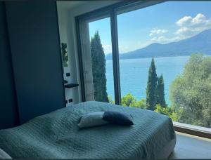 Dormitorio con cama y vistas al agua en 3 Zimmer Apartment am Gardasee mit traumhaften Seeblick und Pool in Torri del Benaco, en Torri del Benaco 18 fotos más