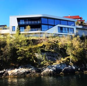 a building on a hill next to the water at Villa EA Bergen in Bergen