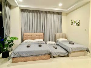 a bedroom with two beds in front of a window at Kuching City Center Riverine Apartment With Balcony and Marvelous View in Kuching +64 photos