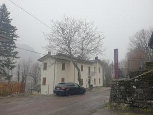 a black car parked in front of a white house at Locanda In Montagna Da Emili&Gabriel in Lizzano in Belvedere +17 photos