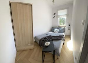 a small bedroom with a bed and a small table at Apartament Sun in Sztutowo