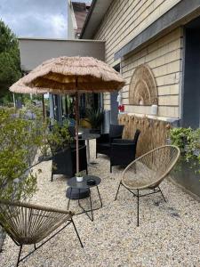 a patio with a table and an umbrella and chairs at Hotel Best Western La Mare Ô Poissons in Ouistreham