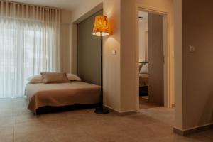 a bedroom with a bed and a floor lamp at Dantis Place Alpha1 in Nafplio
