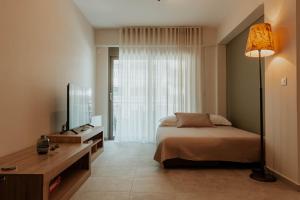 a bedroom with a bed and a desk and a television at Dantis Place Alpha1 in Nafplio