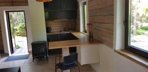 a kitchen with a counter and chairs in a room at Jaukūs namai Kulautuvoje in Kulautuva
