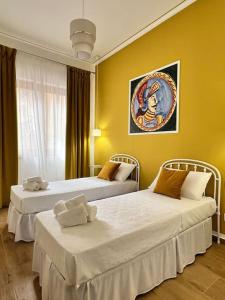 two beds in a room with yellow walls at Casa Vacanze Tirreno in Trabia +61 photos