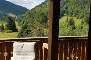 a balcony with a chair and a view of a mountain at Duplex dans chalet, vue de rêve, 6 pers, 2 nuits minimum in La Bresse