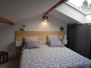 a bedroom with a large bed with two pillows at Duplex dans chalet, vue de rêve, 6 pers, 2 nuits minimum in La Bresse