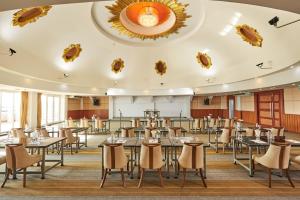 uma grande sala de jantar com mesas e cadeiras em Cozy Donmueang Hotel em Lak Si