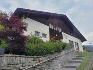 a house with a stone retaining wall and flowers at Ostello Pro Osco in Faido
