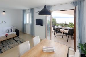 a living room with a dining table and a balcony at Apartments Via Sole Dramalj in Dramalj