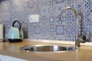 a sink in a kitchen with a blue and white wallpaper at Apartments Via Sole Dramalj in Dramalj +79 photos