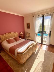 a bedroom with a bed and a large window at Les Hauts de Courrech in Grézels