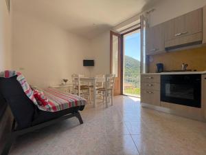 a living room with a kitchen and a table with chairs at Medioevo Mare in Pisciotta
