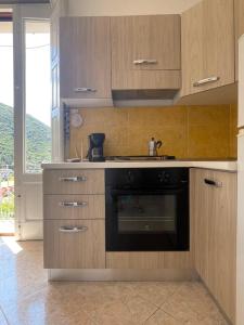 a kitchen with wooden cabinets and a black oven at Medioevo Mare in Pisciotta