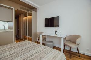 a bedroom with a bed and a table with a chair at Viva beach Apartments in Batumi