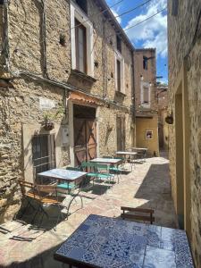 a patio with tables and benches in a building at Medioevo Mare in Pisciotta