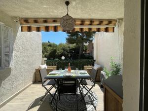 a patio with a table and chairs on a porch at STUDIO 109 GRANDE TERRASSE Mer proche in Bandol