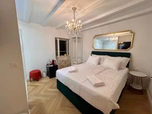 a bedroom with a bed with a mirror and a chandelier at Karma Suites by Dominium in Dubrovnik