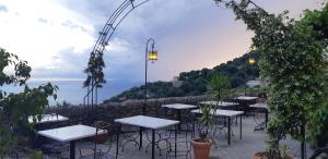a row of tables and chairs on a patio overlooking the ocean at Cozy Studio in Pisciotta +28 photos