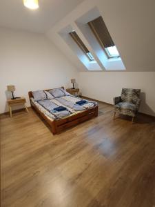 a bedroom with a bed and a chair and skylights at Apartamenty Lubkowo in Lubkowo +55 photos