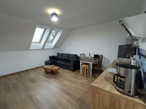 a living room with a couch and a table at Apartamenty Lubkowo in Lubkowo