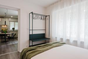 a bedroom with a bed and a dining room at Residenza al Parco in Gorizia